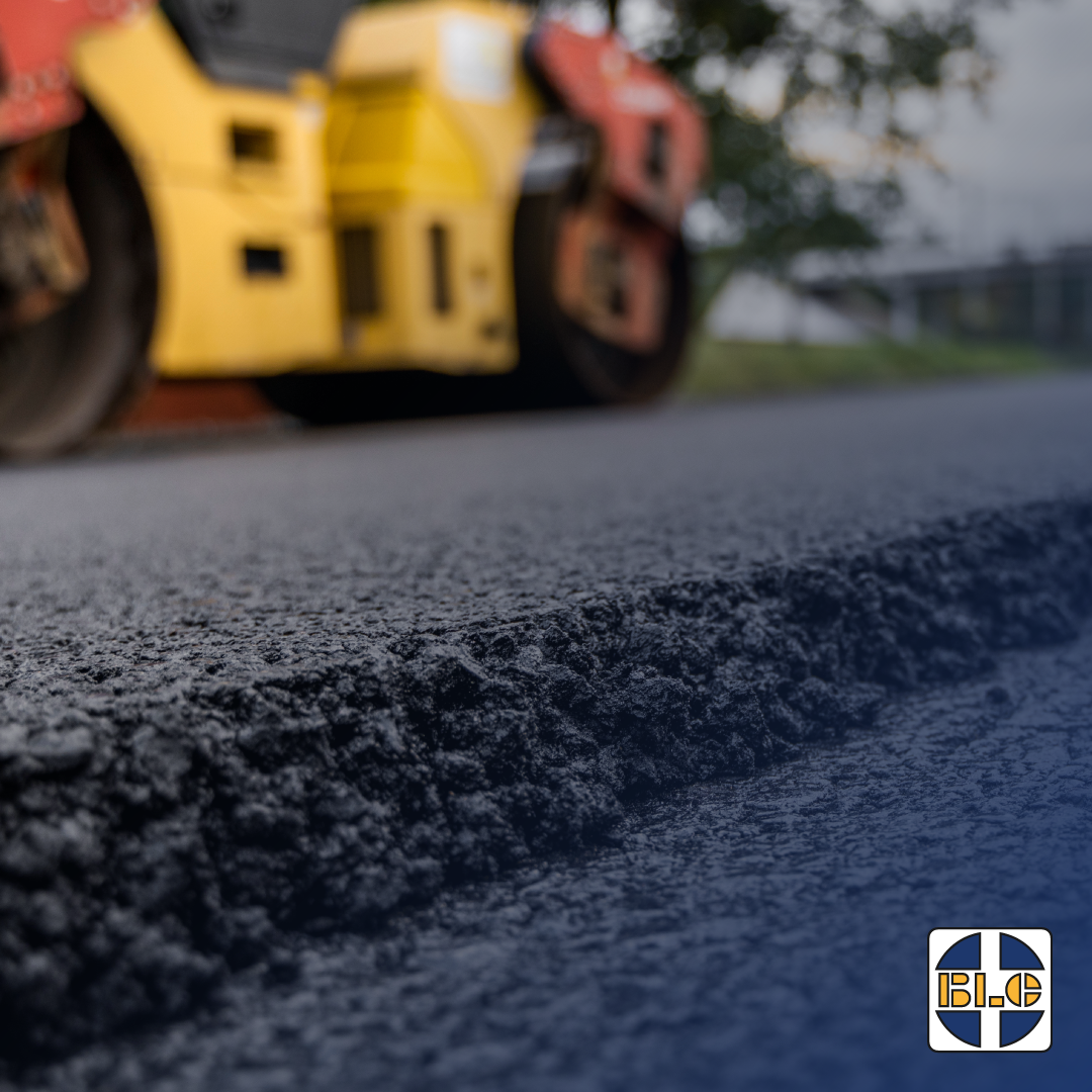 Road roller compacting asphalt surface during road construction with BLC Plant branding