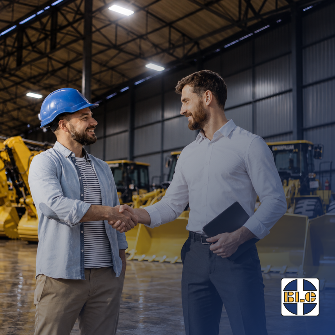 Customer and equipment supplier shaking hands beside used heavy equipment at BLC Plant